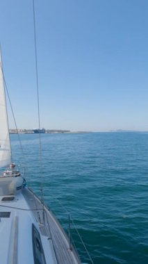 Güneşli bir yaz gününde Vigo 'nun limanında dolaşmak, sakin bir yelkenli korkuluğu ve arka planda Ces Adaları tarafından çerçevelenmek..