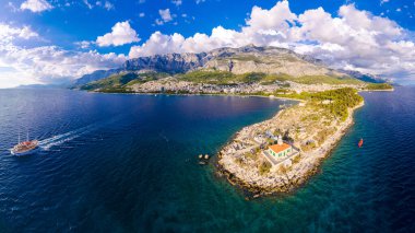 Hırvatistan 'ın Makarska kentinin insansız hava görüntüsü. Şehrin üzerinde gün batımı, sahil ve sette. Arka planda Biokovo dağları var. Yaz zamanı..