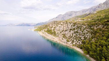 Hırvatistan 'ın Krvavica kentinde turkuaz Adriyatik denizi ve kayalık kıyı
