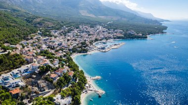 Podgora, Makarska, Dalmaçya ve Hırvat sahillerinde mavi denize karşı tekneleri olan inanılmaz bir sahil.