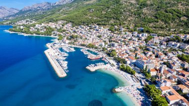 Podgora, Makarska, Dalmaçya ve Hırvat sahillerinde mavi denize karşı tekneleri olan inanılmaz bir sahil.