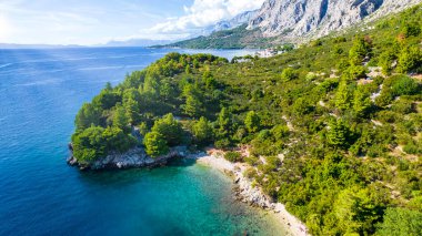 Hırvatistan. Kumsaldaki hava manzarası ve insanlar. Tatil ve rahatlama. Kumsal ve mavi su. Kumsaldaki ve gök mavisi denizdeki İHA 'nın üst görüntüsü. Seyahat ve tatil