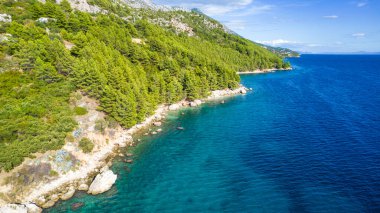 Hırvatistan. Kumsaldaki hava manzarası ve insanlar. Tatil ve rahatlama. Kumsal ve mavi su. Kumsaldaki ve gök mavisi denizdeki İHA 'nın üst görüntüsü. Seyahat ve tatil