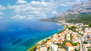 Panorama of Baska Voda town with harbor against mountains in Makarska riviera, Dalmatia, Croatia