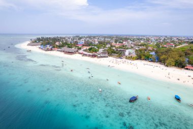 Zanzibar 'da Zanzibar' da Zanzibar 'daki Nungwi sahilinde yürüyen insanlarla güzel bir günbatımı görüntüsü.