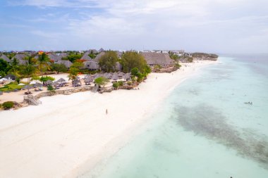 Zanzibar 'da Zanzibar' da Zanzibar 'daki Nungwi sahilinde yürüyen insanlarla güzel bir günbatımı görüntüsü.