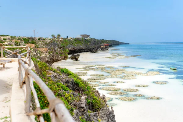 Landscape of the Indian Ocean coastline with at Mtende Beach, Zanzibar. Rocks and white sand. View from the sea