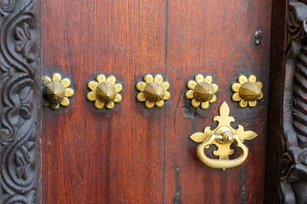 Traditional arab zanzibar wooden door and doorway ornately carved and decorated with brass fittings