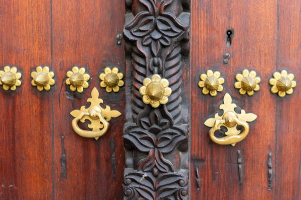 Traditional arab zanzibar wooden door and doorway ornately carved and decorated with brass fittings