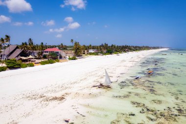 Zanzibar looks like paradise in this drone shot, with a beautiful beach and wooden boats left behind at low tide.