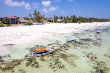 Zanzibar looks like paradise in this drone shot, with a beautiful beach and wooden boats left behind at low tide.