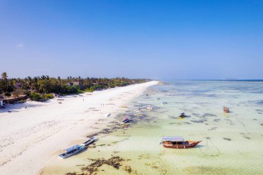 Zanzibar looks like paradise in this drone shot, with a beautiful beach and wooden boats left behind at low tide.