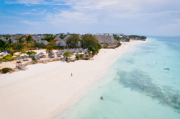 This drone shot of Nungwi Beach in Zanzibar captures the incredible beauty of the shoreline, with crystal-clear waters and golden sand providing a picture-perfect view.