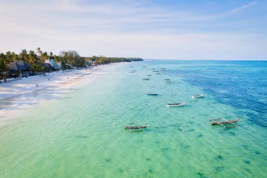 Indulge in a luxurious getaway at Zanzibar's Kiwengwa beach, where the white sand, turquoise waters, and palm trees create a serene and refreshing atmosphere for a truly memorable vacation.