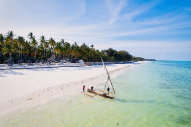 Indulge in a luxurious getaway at Zanzibar's Kiwengwa beach, where the white sand, turquoise waters, and palm trees create a serene and refreshing atmosphere for a truly memorable vacation.