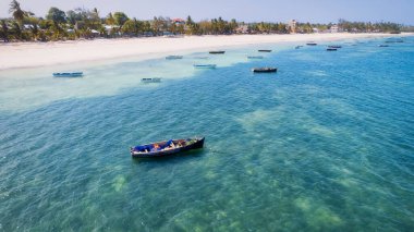 Indulge in a luxurious getaway at Zanzibar's Kiwengwa beach, where the white sand, turquoise waters, and palm trees create a serene and refreshing atmosphere for a truly memorable vacation.