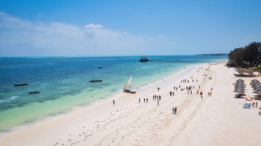 Indulge in a luxurious getaway at Zanzibar's Kiwengwa beach, where the white sand, turquoise waters, and palm trees create a serene and refreshing atmosphere for a truly memorable vacation.