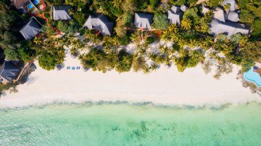 The stunning beauty of Kiwengwa beach in Zanzibar is on full display in this mesmerizing aerial drone footage, showcasing its palm tree-lined shore and turquoise waters