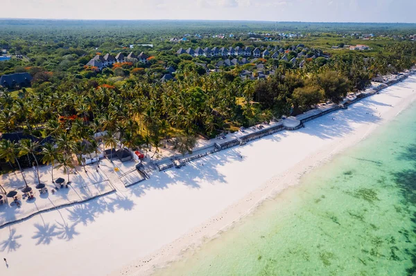 Get lost in the beauty of Zanzibar\'s idyllic palm-fringed beach and shimmering blue ocean in this captivating drone photo, the perfect inspiration for your next travel adventure.