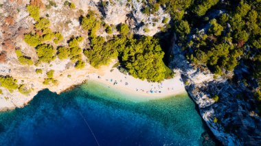 Enjoy the view of Croatia's beach from above, where turquoise waters meet soft sands. Relax and find adventure in this beautiful vacation spot, captured in stunning aerial photography.