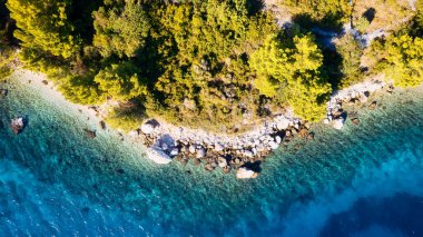 The stunning beauty of Croatia's rocks and forests is captured in this breathtaking aerial view. Take in the turquoise waters and beach from above, and add this travel image to your collection of unforgettable memories.