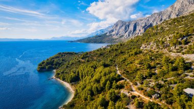 Enjoy the view of Croatia's beach from above, where turquoise waters meet soft sands. Relax and find adventure in this beautiful vacation spot, captured in stunning aerial photography.