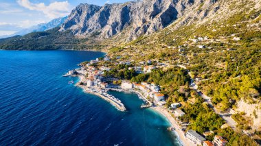 Croatia's harbor is a sight to behold from above. This breathtaking aerial view captures the colorful landscape filled with sailboats, motorboats, and luxurious yachts resting in a clear blue bay. Add this travel image to your collection of 