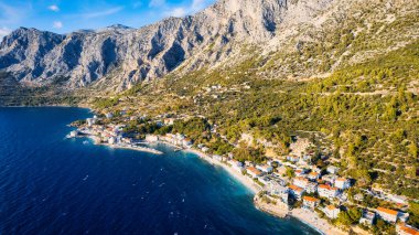 Croatia's harbor is a sight to behold from above. This breathtaking aerial view captures the colorful landscape filled with sailboats, motorboats, and luxurious yachts resting in a clear blue bay. Add this travel image to your collection of 