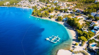 Enjoy the view of Croatia's beach from above, where turquoise waters meet soft sands. Relax and find adventure in this beautiful vacation spot, captured in stunning aerial photography.