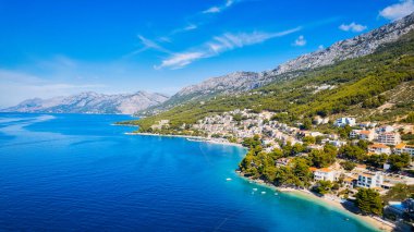 Turkuaz suların yumuşak kumlarla buluştuğu Hırvatistan plajının keyfini çıkarın. Rahatla ve bu güzel tatil yerinde sersemletici hava fotoğraflarıyla yakalanan macerayı bul..