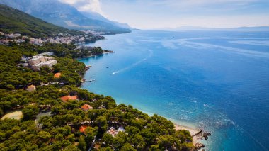 A drone captured the stunning aerial view of Croatia's coastal area, which features crystal-clear blue water and lush forests on land.