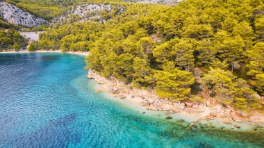 The stunning beauty of Croatia's rocks and forests is captured in this breathtaking aerial view. Take in the turquoise waters and beach from above, and add this travel image to your collection of unforgettable memories.