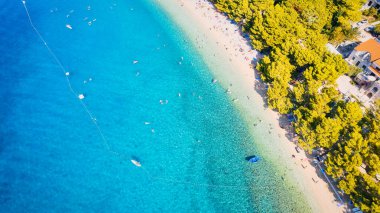 Hırvatistan 'ın büyüleyici kıyı kenti Makarska' ya yeni bir perspektiften bakın. Güneşli bir günde bu muhteşem insansız hava aracı çekim panoramasıyla..