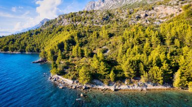 Marvel at the stunning aerial perspective of Croatia's Makarska Riviera, displaying a rocky beach and the captivating turquoise water.