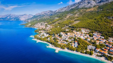 Take in the beauty of Croatia's coastal region from a new perspective with this stunning drone view, which features clear blue water and forested land.