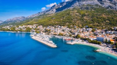 Hırvatistan 'ın büyüleyici kıyı kenti Makarska' ya yeni bir perspektiften bakın. Güneşli bir günde bu muhteşem insansız hava aracı çekim panoramasıyla..