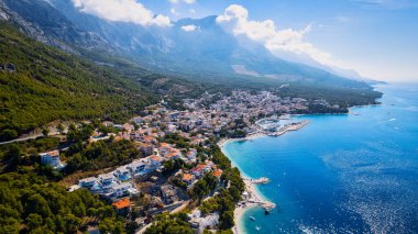 Take in the beauty of Croatia's coastal region from a new perspective with this stunning drone view, which features clear blue water and forested land.