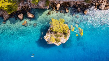 Take in the beauty of Croatia's coastal region from a new perspective with this stunning drone view, which features clear blue water and forested land.