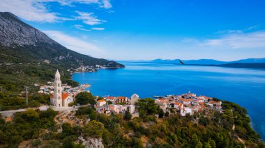 Hırvatistan 'ın büyüleyici kıyı kenti Makarska' ya yeni bir perspektiften bakın. Güneşli bir günde bu muhteşem insansız hava aracı çekim panoramasıyla..