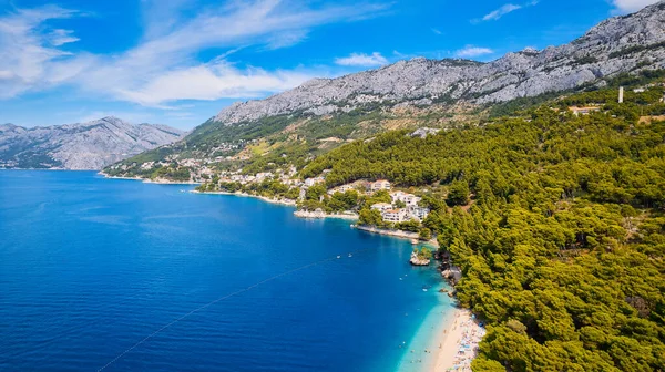 Take in the beauty of Croatia's coastal region from a new perspective with this stunning drone view, which features clear blue water and forested land.