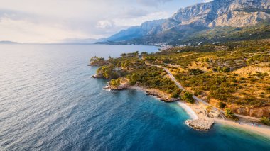 Hırvatistan 'ın Makarska Riviera kentinin büyüleyici hava perspektifi, kayalık bir plaj ve büyüleyici turkuaz suyu sergiliyor..