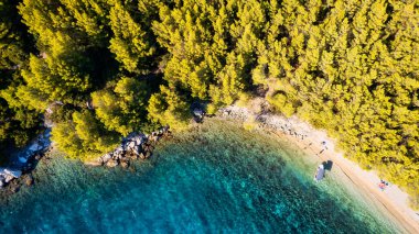 Take in the breathtaking aerial view of Makarska Riviera in Croatia, revealing a picturesque rocky beach and the vibrant turquoise water.