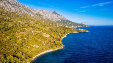 Take in the breathtaking aerial view of Makarska Riviera in Croatia, revealing a picturesque rocky beach and the vibrant turquoise water.