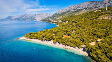Hırvatistan 'daki Makarska Riviera' nın nefes kesici hava manzarasını ele alalım. Resimli kayalık bir plaj ve canlı turkuaz suyu gözler önüne seriyor..