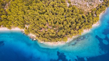 Take in the breathtaking aerial view of Makarska Riviera in Croatia, revealing a picturesque rocky beach and the vibrant turquoise water.