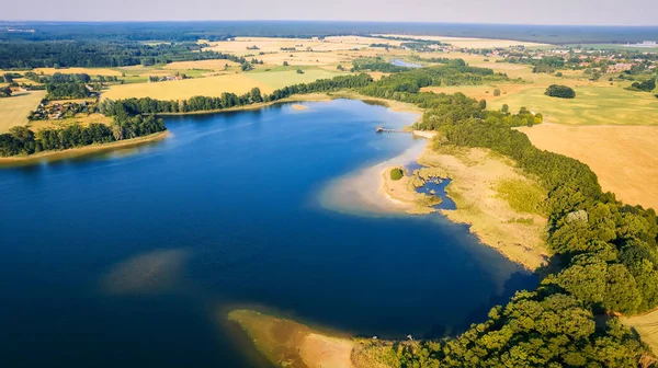 This stunning drone panorama captures a lake in Poland\'s Lubuskie Voivodeship on a bright and sunny spring day