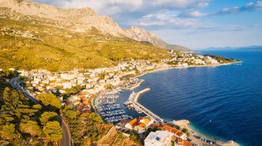 Hırvatistan 'ın büyüleyici kıyı kenti Makarska' ya yeni bir perspektiften bakın. Güneşli bir günde bu muhteşem insansız hava aracı çekim panoramasıyla..