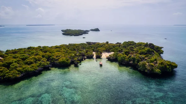 Get lost in the beauty of Zanzibar's idyllic palm-fringed beach and shimmering blue ocean in this captivating drone photo, the perfect inspiration for your next travel adventure.
