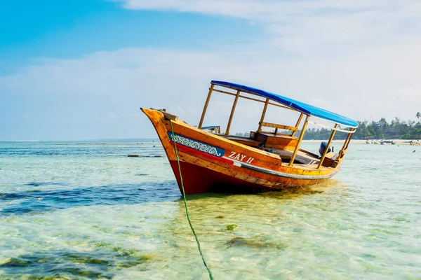 Experience the beauty of Zanzibar\'s tropical coast from a bird\'s eye view, with fishing boats resting on the sandy beach at sunrise. The top-down perspective showcases clear blue waters, green palm trees, and even a yacht.
