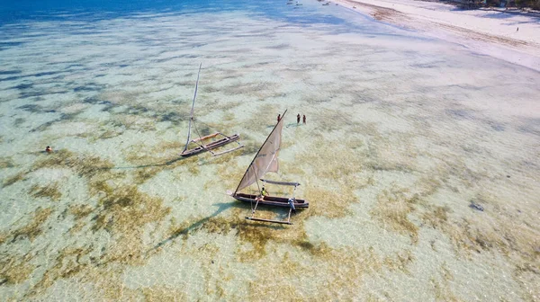 Zanzibarの熱帯海岸の美しさを鳥の目のビューから体験してください 日の出には漁船が砂浜に休んでいます トップダウンの展望台には 澄んだ青い海 緑のヤシの木 さらにはヨットもあります — ストック写真